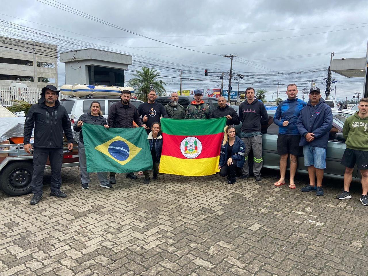 Equipe de voluntários reunida com as bandeiras do Brasil e do Rio Grande do Sul